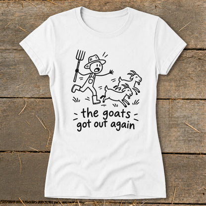 White t-shirt with black line art of a farmer chasing goats, text reads "the goats got out again".