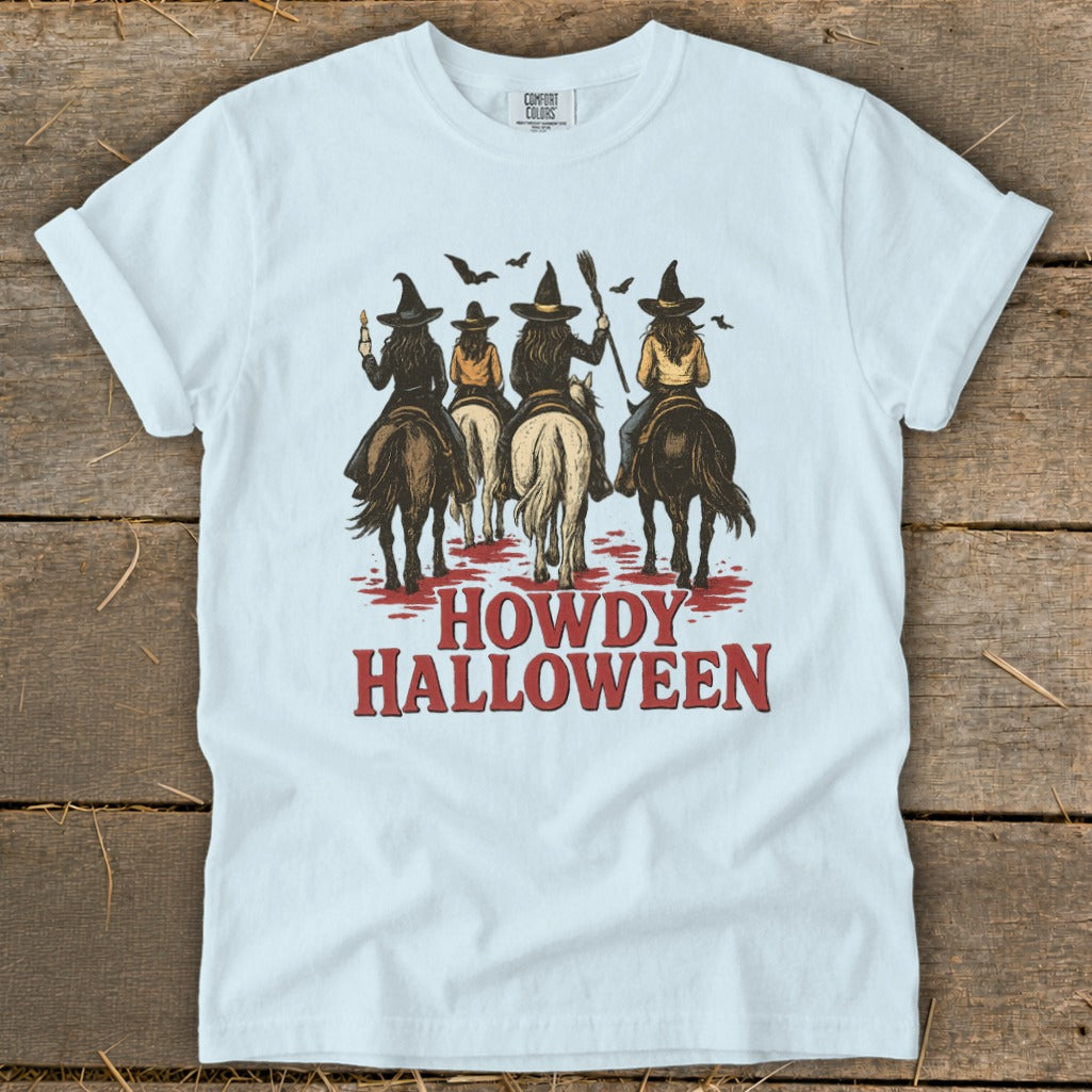 White t-shirt with "Howdy Halloween" text and four witches riding horses.