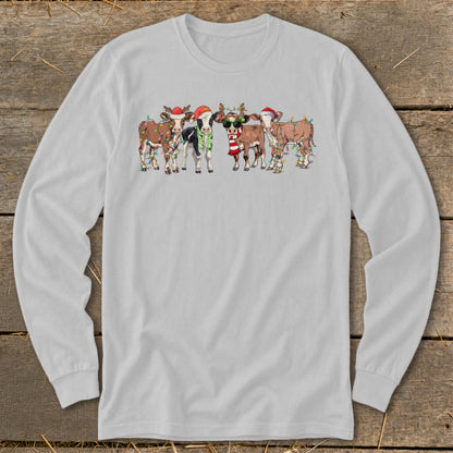 Five cows wearing festive Christmas hats and lights stand together.