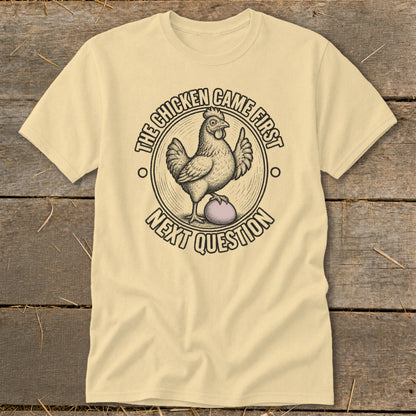 Light yellow t-shirt with a chicken on an egg, saying "The chicken came first. Next question."