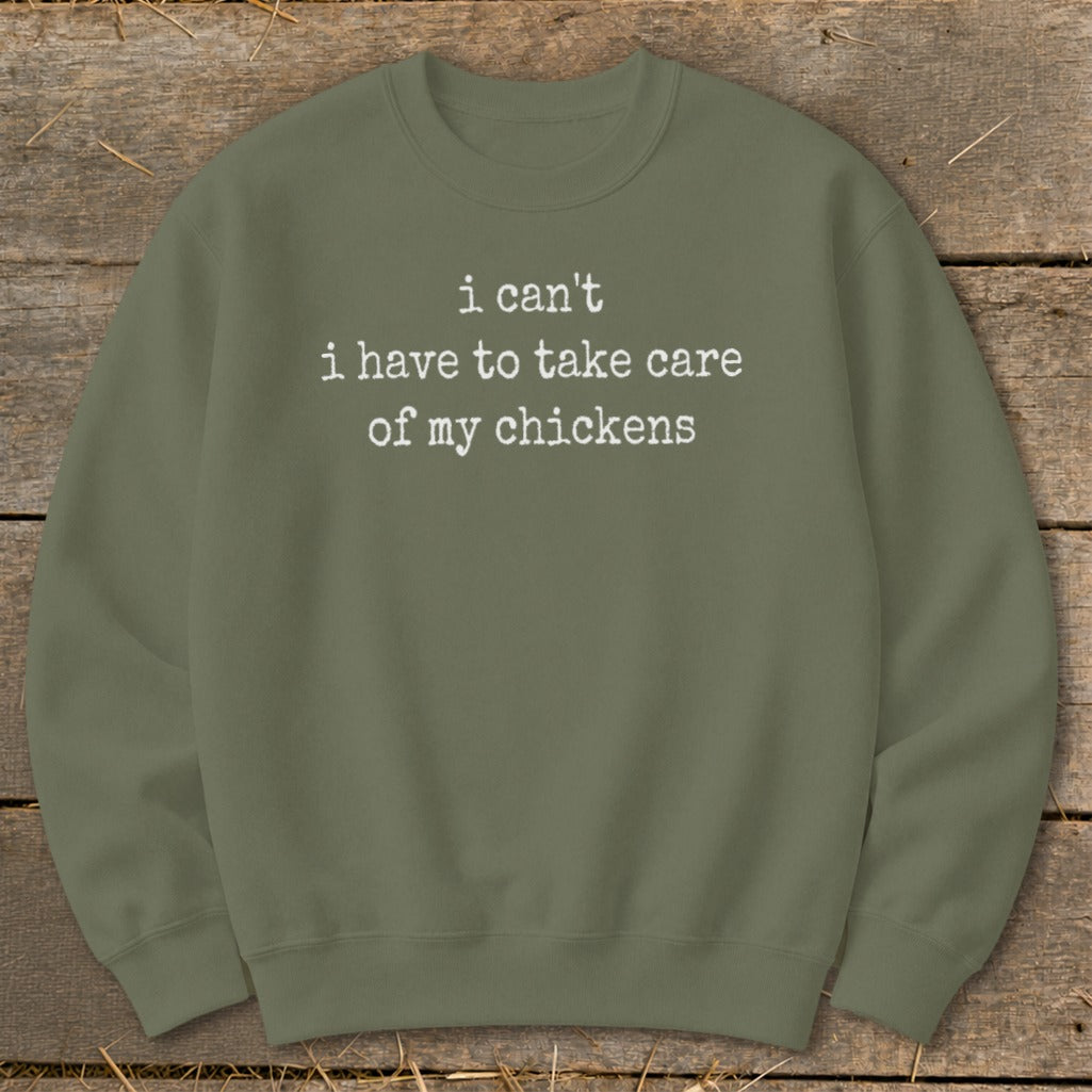 Olive green sweatshirt with white text that reads "i can't i have to take care of my chickens".