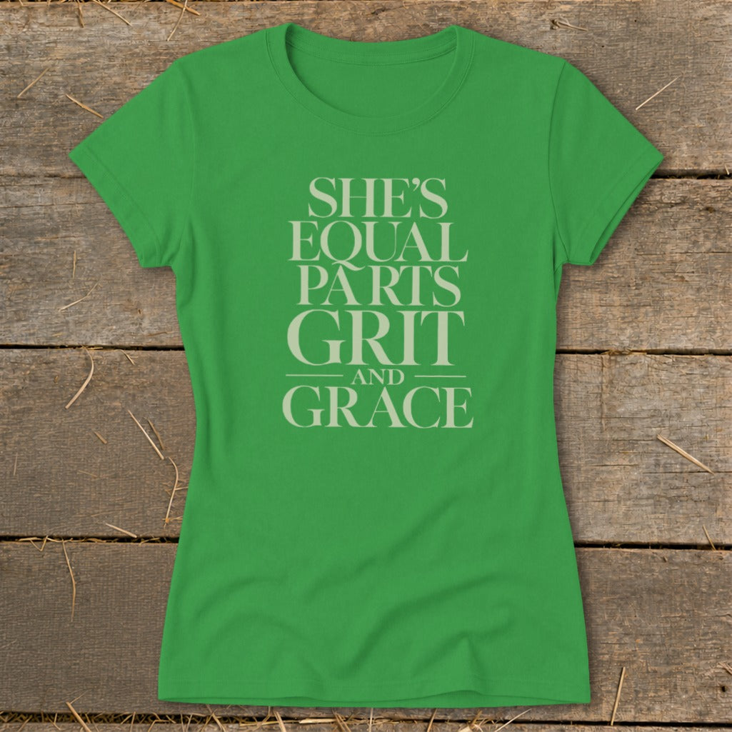 Green t-shirt with light grey text reading "SHE'S EQUAL PARTS GRIT AND GRACE".
