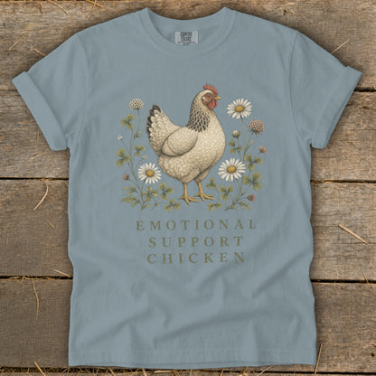 Light blue t-shirt with a chicken, clover, and daisies, reads "Emotional Support Chicken".