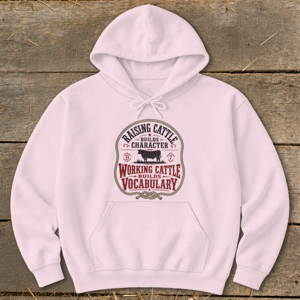 Pink hoodie with distressed "Raising Cattle Builds Character" and "Working Cattle Builds Vocabulary" graphic.