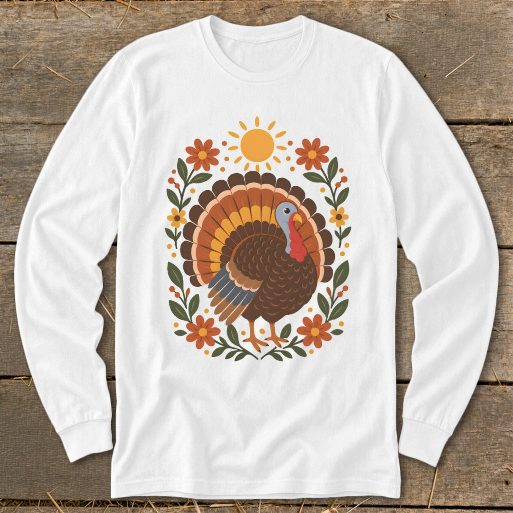 White long-sleeve shirt featuring a Thanksgiving turkey illustration surrounded by flowers and a sun.