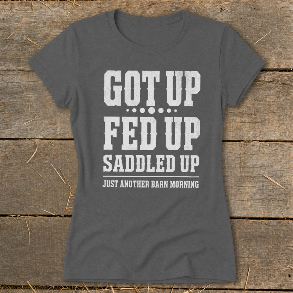 Dark gray t-shirt with white text reading "GOT UP FED UP SADDLED UP JUST ANOTHER BARN MORNING".