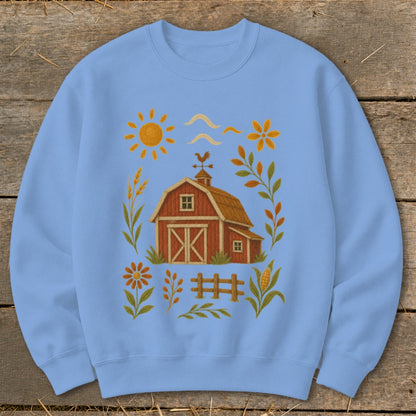 Light blue sweatshirt with a barn, sun, flowers, and corn illustration.