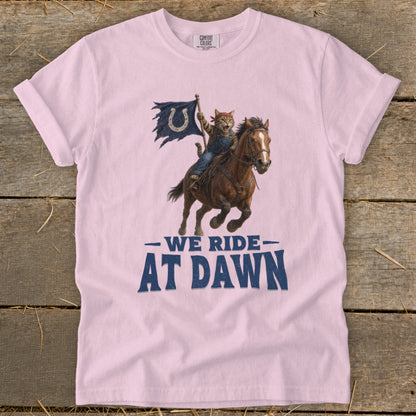 Cat in overalls rides a horse, waving a flag with text "WE RIDE AT DAWN".