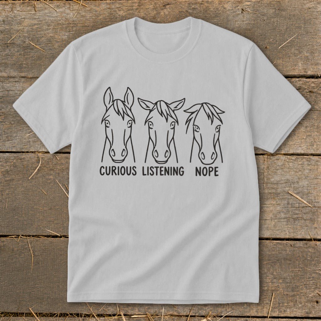 A light gray crewneck t-shirt featuring three horse head sketches with the captions curious, listening, and nope.