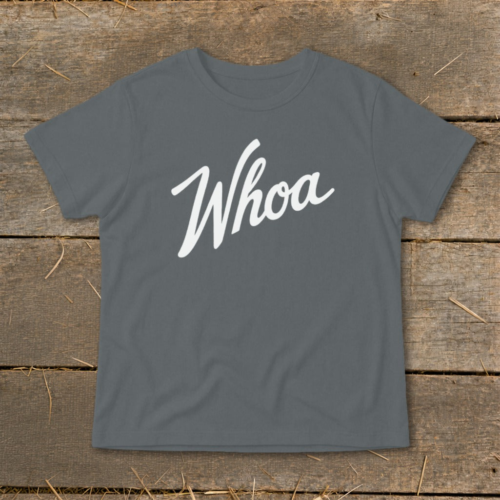 Gray t-shirt with white "Whoa" text, laid on wooden planks.