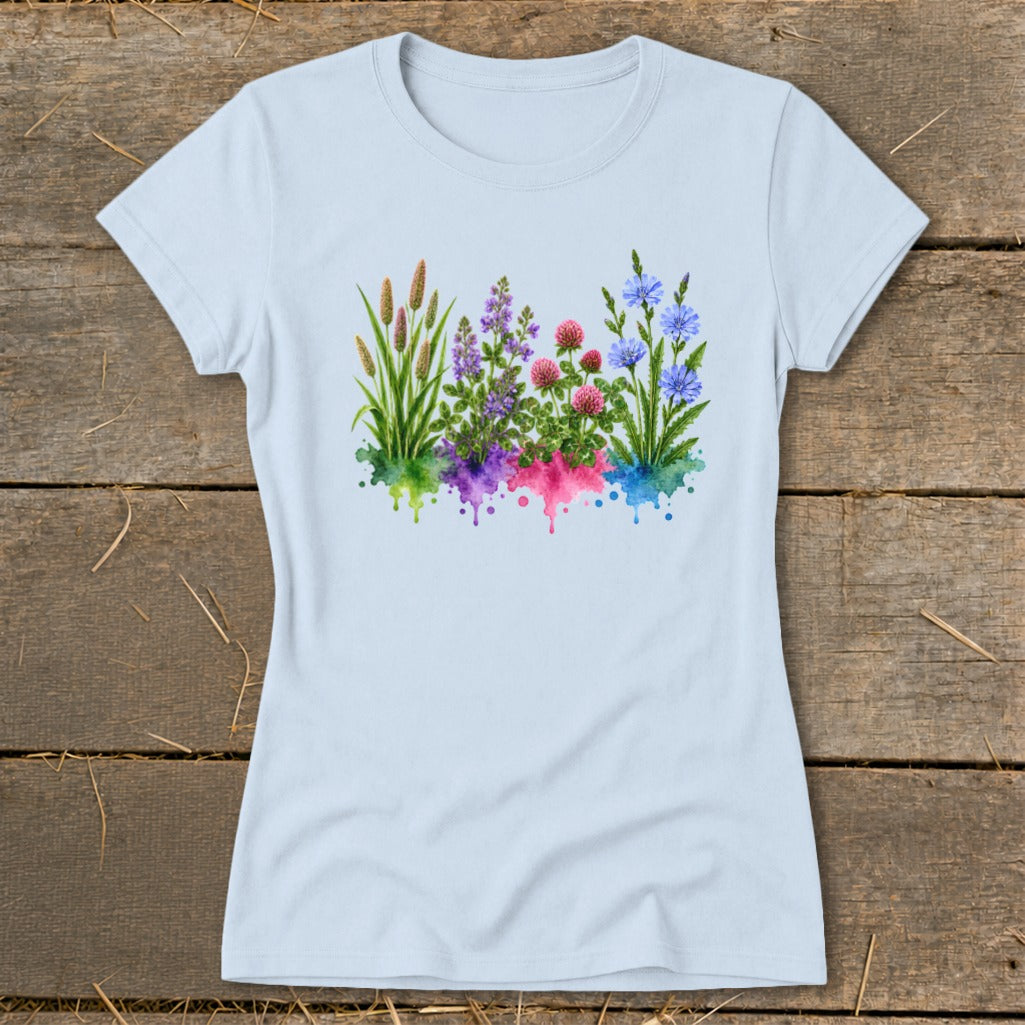 Light blue women's t-shirt featuring a colorful watercolor botanical print of wildflowers on a wooden background.