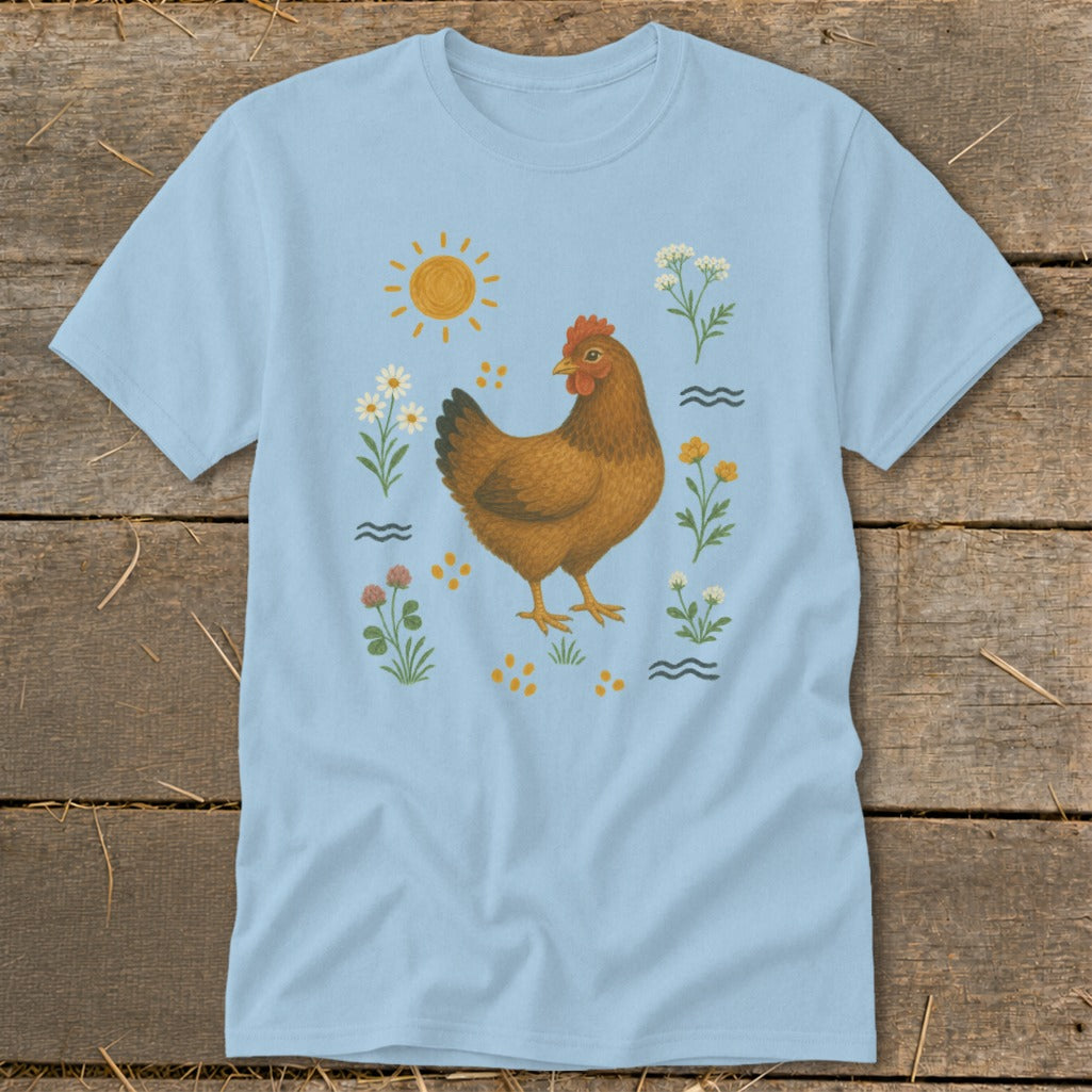 Light blue t-shirt with a brown hen surrounded by flowers, sun, and scattered dots.
