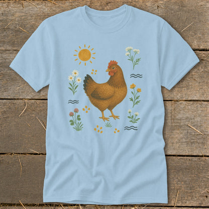 Light blue t-shirt with a brown hen surrounded by flowers, sun, and scattered dots.