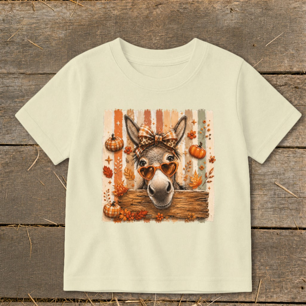 Donkey wearing heart sunglasses and bow, with pumpkins and fall leaves.