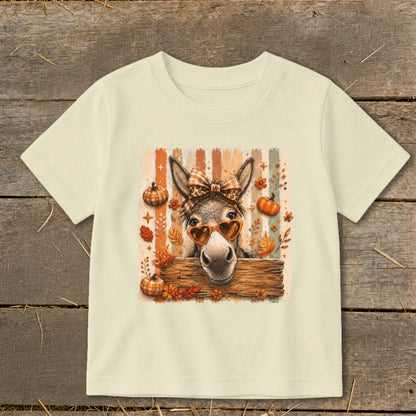 Donkey wearing heart sunglasses and bow, with pumpkins and fall leaves.