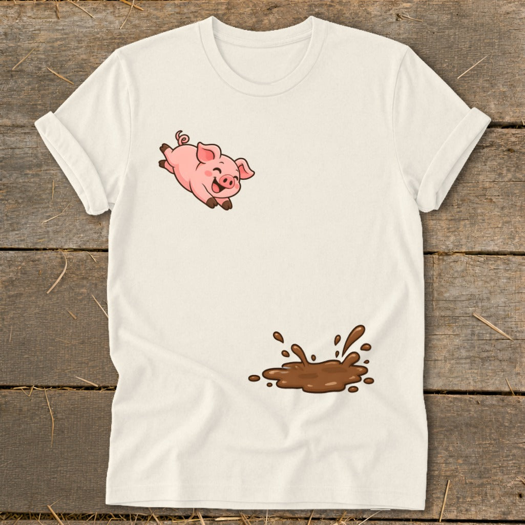 Cream t-shirt with a jumping cartoon pig and a splash of mud.