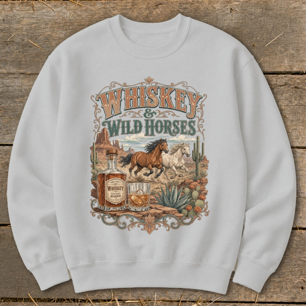 Whiskey and Wild Horses graphic on a white sweatshirt with a desert scene.