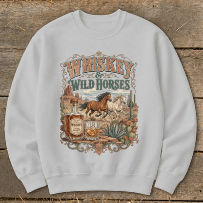 Whiskey and Wild Horses graphic on a white sweatshirt with a desert scene.