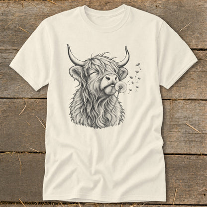 T-shirt with sketch of Highland cow blowing a dandelion, seeds flying.