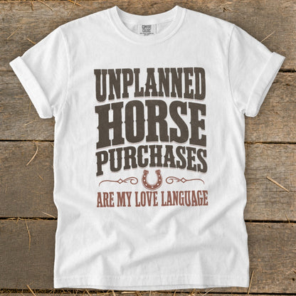 White t-shirt with text "UNPLANNED HORSE PURCHASES ARE MY LOVE LANGUAGE".