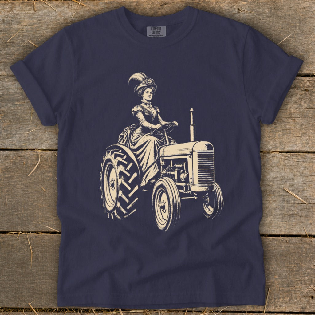 T-shirt graphic of a woman in vintage clothing driving a tractor.
