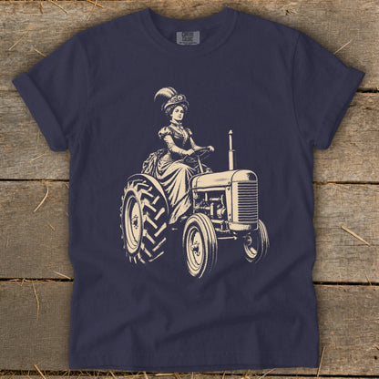 T-shirt graphic of a woman in vintage clothing driving a tractor.