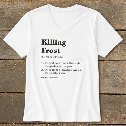 White V-neck t-shirt with black dictionary definition text about a killing frost laid flat on a wooden background.
