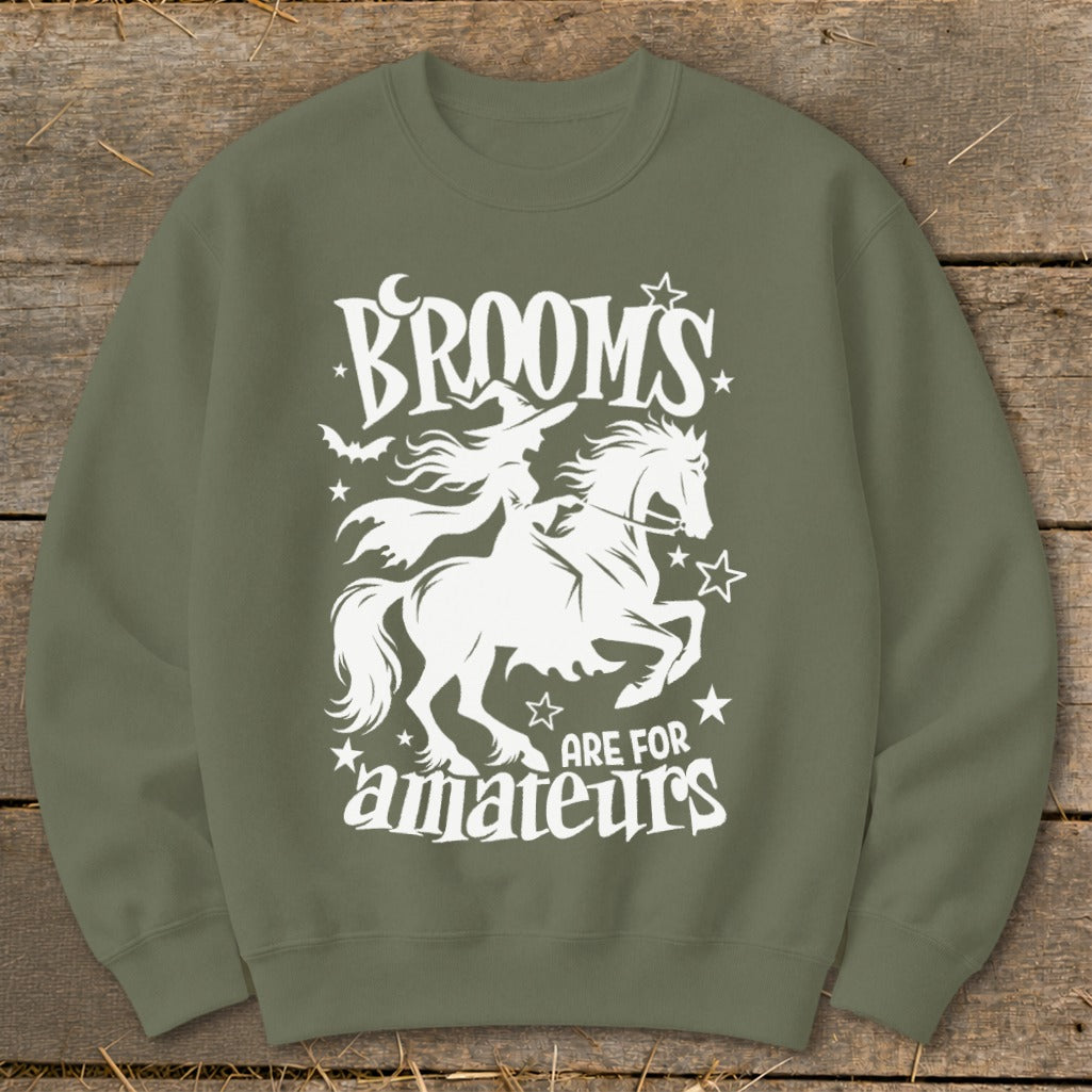 Green sweatshirt with white graphic of a witch on a horse and text "Brooms are for amateurs".