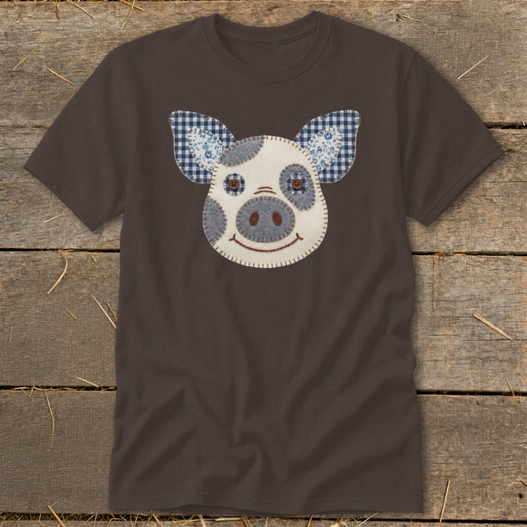 Brown t-shirt with a stitched pig face applique featuring gingham and floral fabric ears.