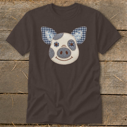 Brown t-shirt with a stitched pig face applique featuring gingham and floral fabric ears.
