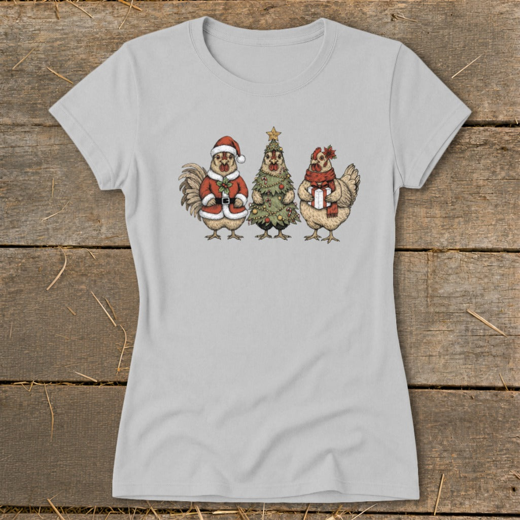 Three cartoon chickens dressed for Christmas: one as Santa, one as a tree, one with a scarf and gift.