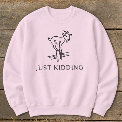 Pink sweatshirt with line drawing of a goat and "JUST KIDDING" text.