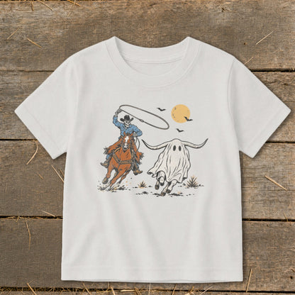 Skeleton cowboy on horseback lassos a ghost longhorn with bats and moon.