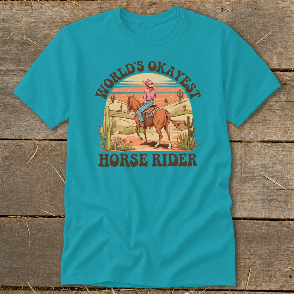 Turquoise t-shirt with desert scene and text "World's Okayest Horse Rider".