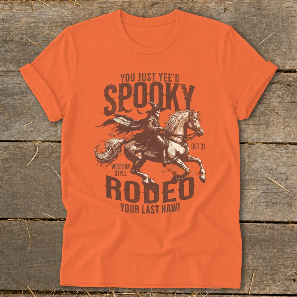 Orange t-shirt with "Spooky Rodeo" graphic featuring a person on horseback, "Oct 31".