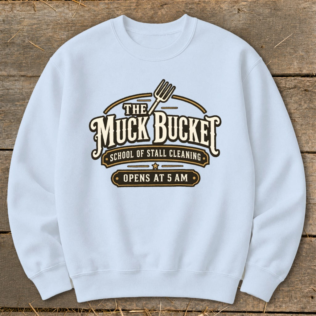 Light blue sweatshirt with "The Muck Bucket School of Stall Cleaning" logo.