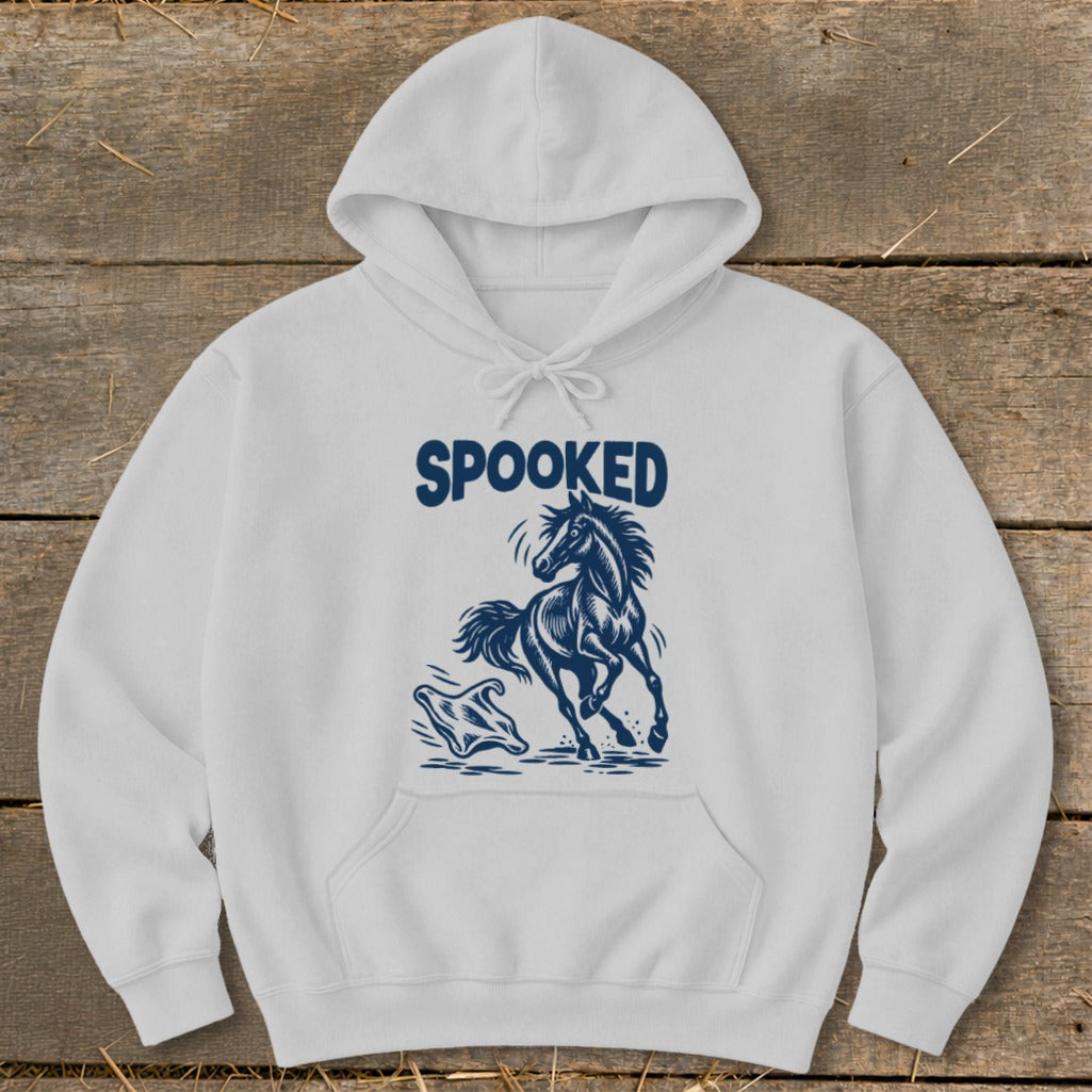 White hoodie with navy "SPOOKED" text and a jumping horse graphic.
