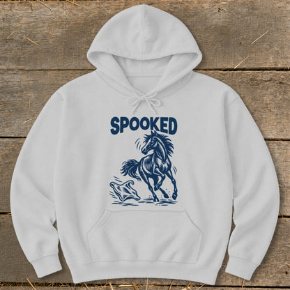 White hoodie with navy "SPOOKED" text and a jumping horse graphic.