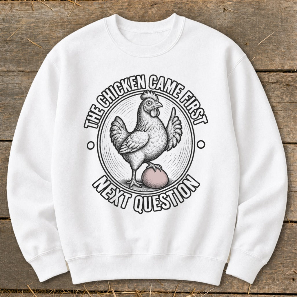 White sweatshirt with a chicken on an egg and text: "The chicken came first, next question."