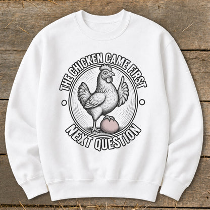 White sweatshirt with a chicken on an egg and text: "The chicken came first, next question."
