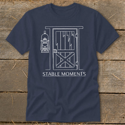 Navy t-shirt with white line drawing of stable door, lantern, and text "STABLE MOMENTS".