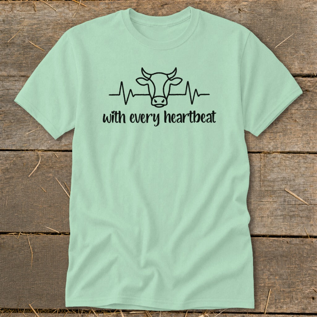 Light green t-shirt with black cow head and heartbeat graphic and text.