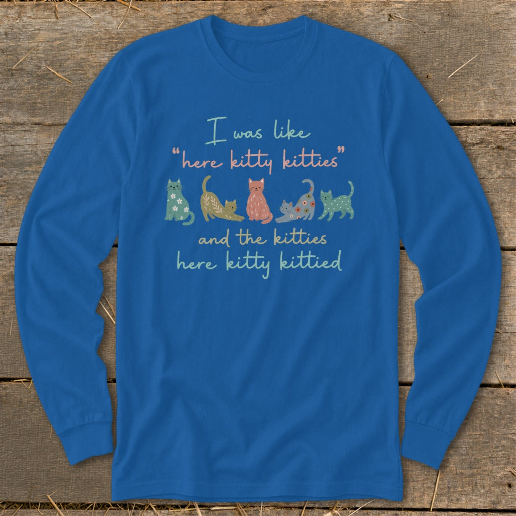 Blue long-sleeve shirt with quote and colorful cartoon kittens.