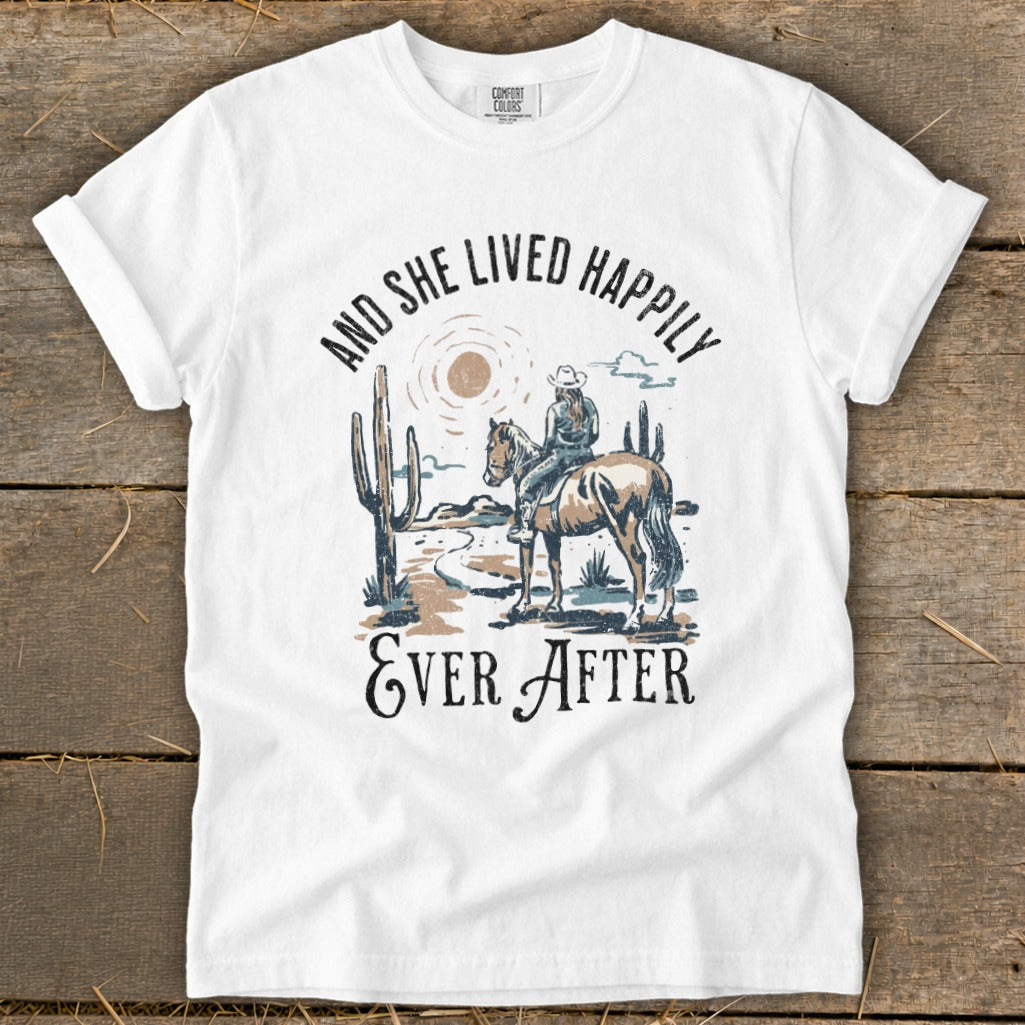 White t-shirt with desert scene and text "And she lived happily ever after".