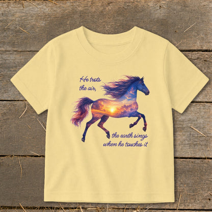 A pale yellow short-sleeved t-shirt features a galloping horse graphic filled with a sunset sky and inspirational text.