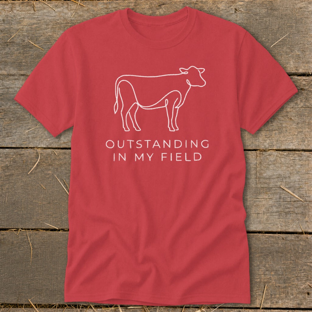 Red t-shirt with white outline of a cow and text "OUTSTANDING IN MY FIELD".