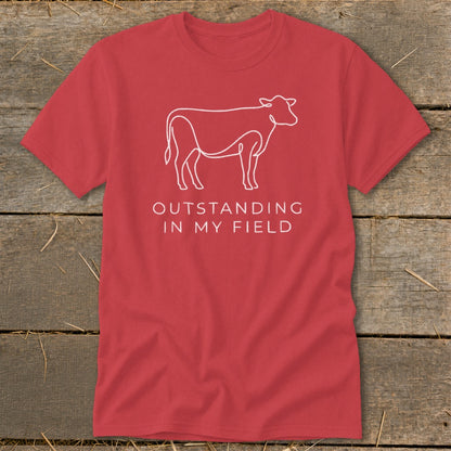 Red t-shirt with white outline of a cow and text "OUTSTANDING IN MY FIELD".
