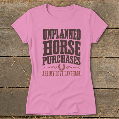 Pink t-shirt with "UNPLANNED HORSE PURCHASES ARE MY LOVE LANGUAGE" text and horseshoe.
