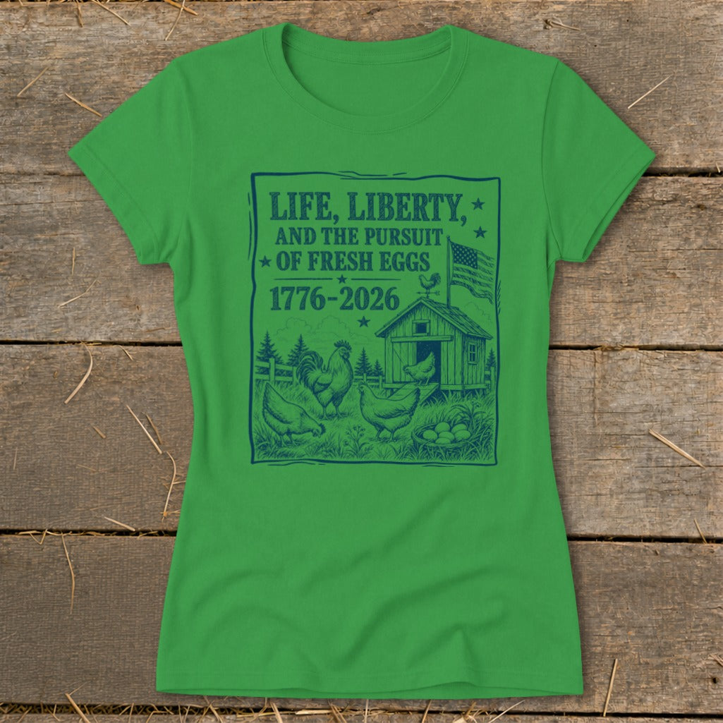 Green t-shirt with "Life, Liberty, and the Pursuit of Fresh Eggs 1776-2026" graphic.