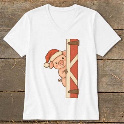 White v-neck t-shirt with a cartoon pig wearing a Santa hat peeking behind a red barn door.